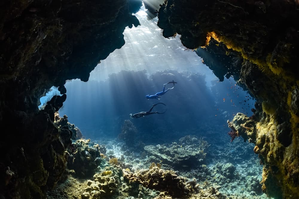 Scuba diver swimming through an underwater cave passage