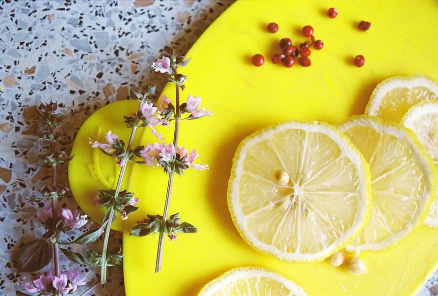 Sliced lemons and fresh herbs on a wooden board