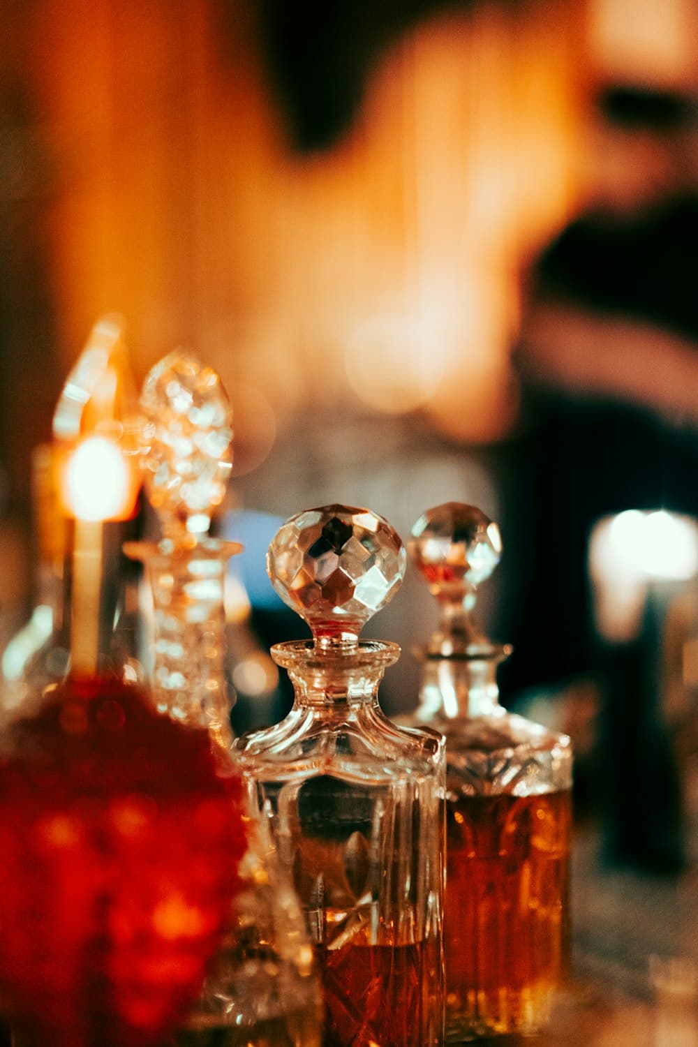 Antique crystal perfume decanters catching warm candlelight