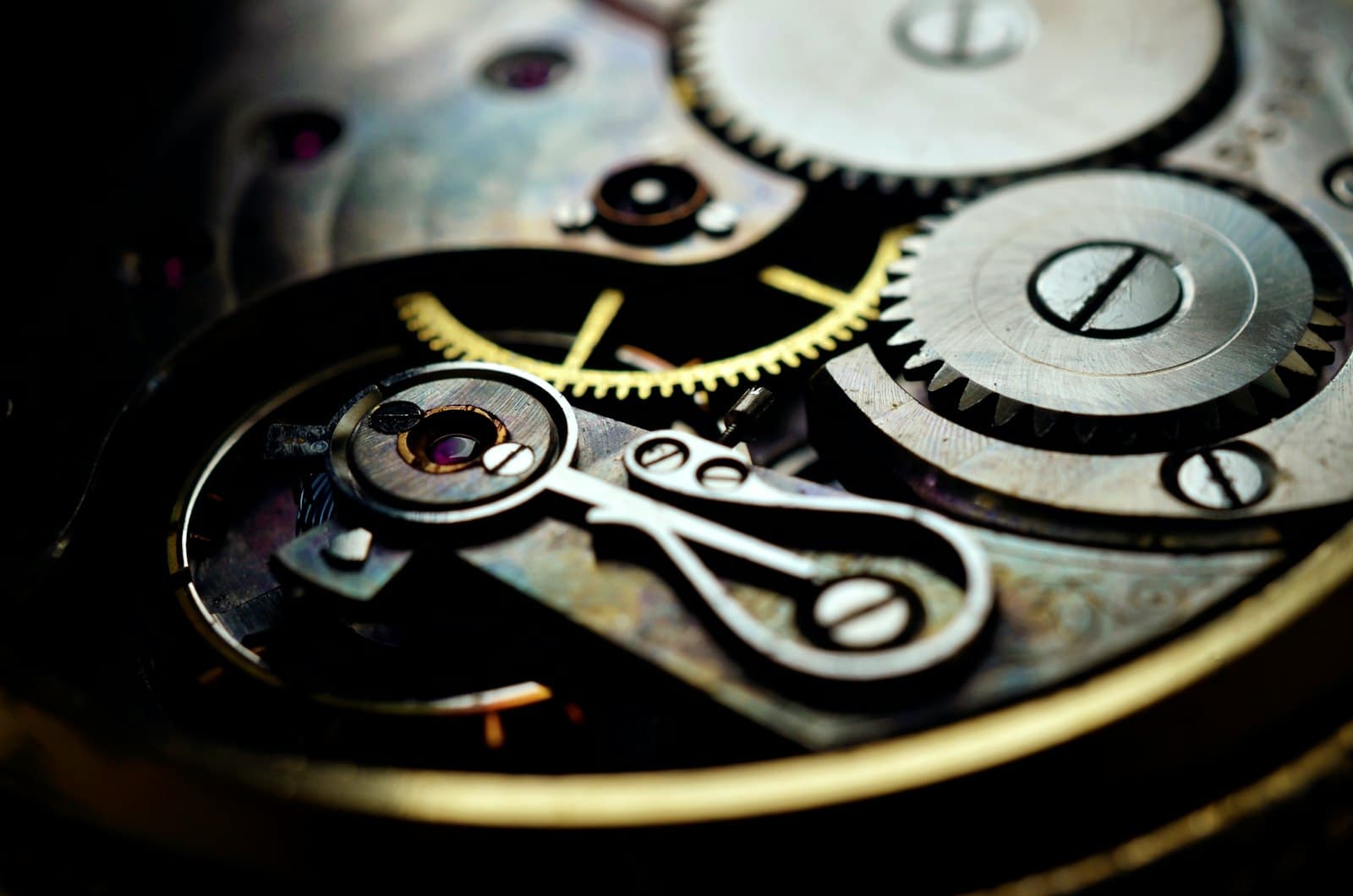 Gold and black steel gears from a winding clock mechanism