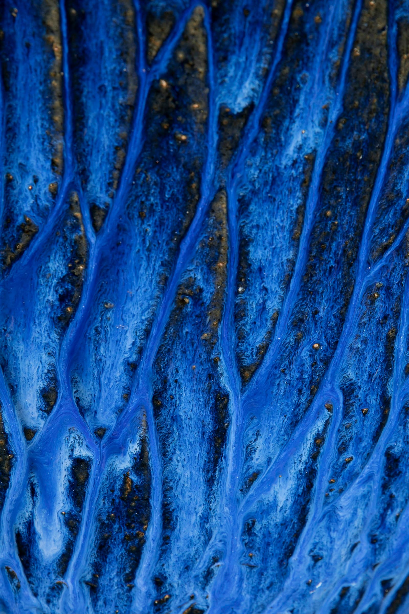 A close-up of a glossy blue ceramic glaze surface