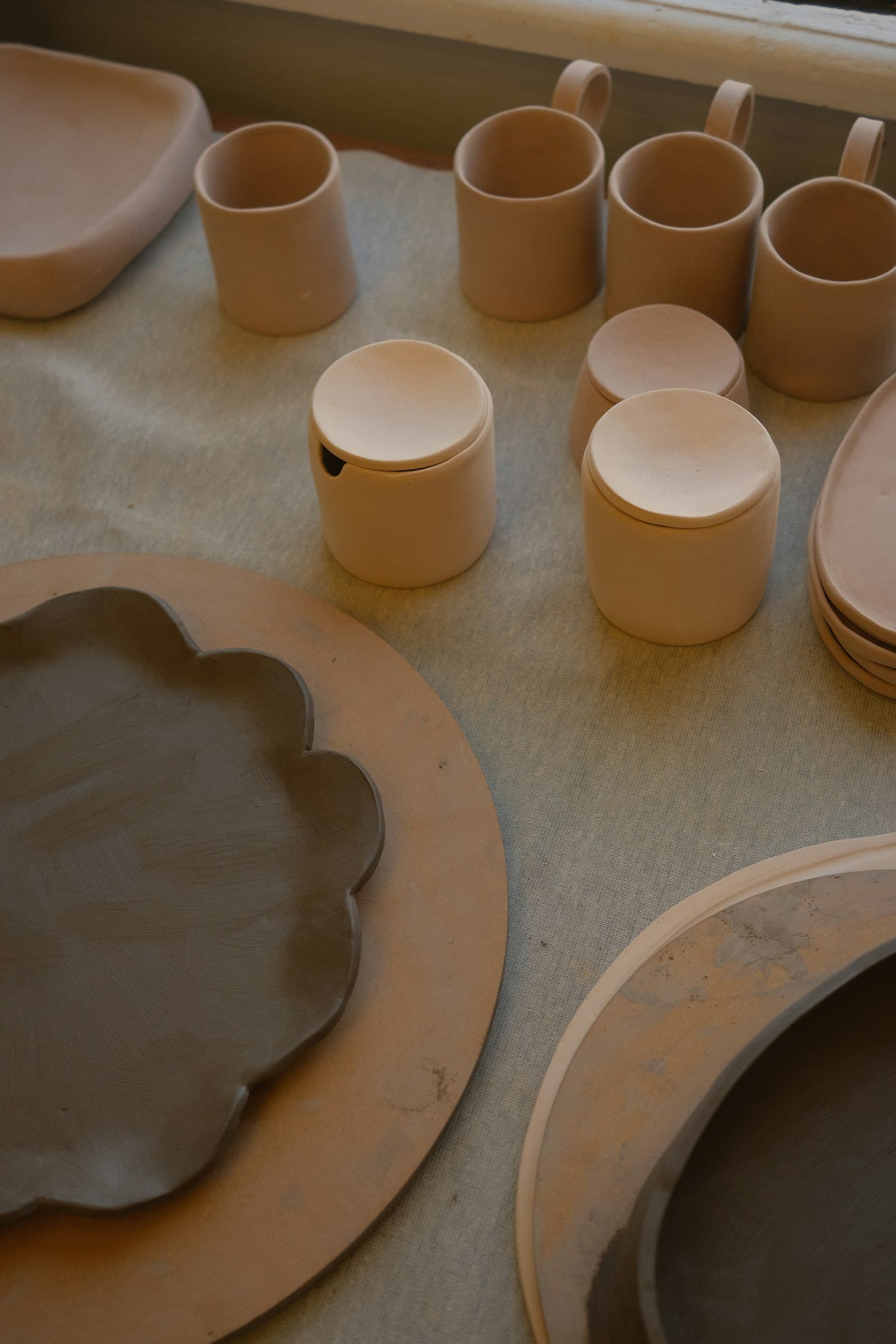 A table topped with an assortment of finished ceramic pieces